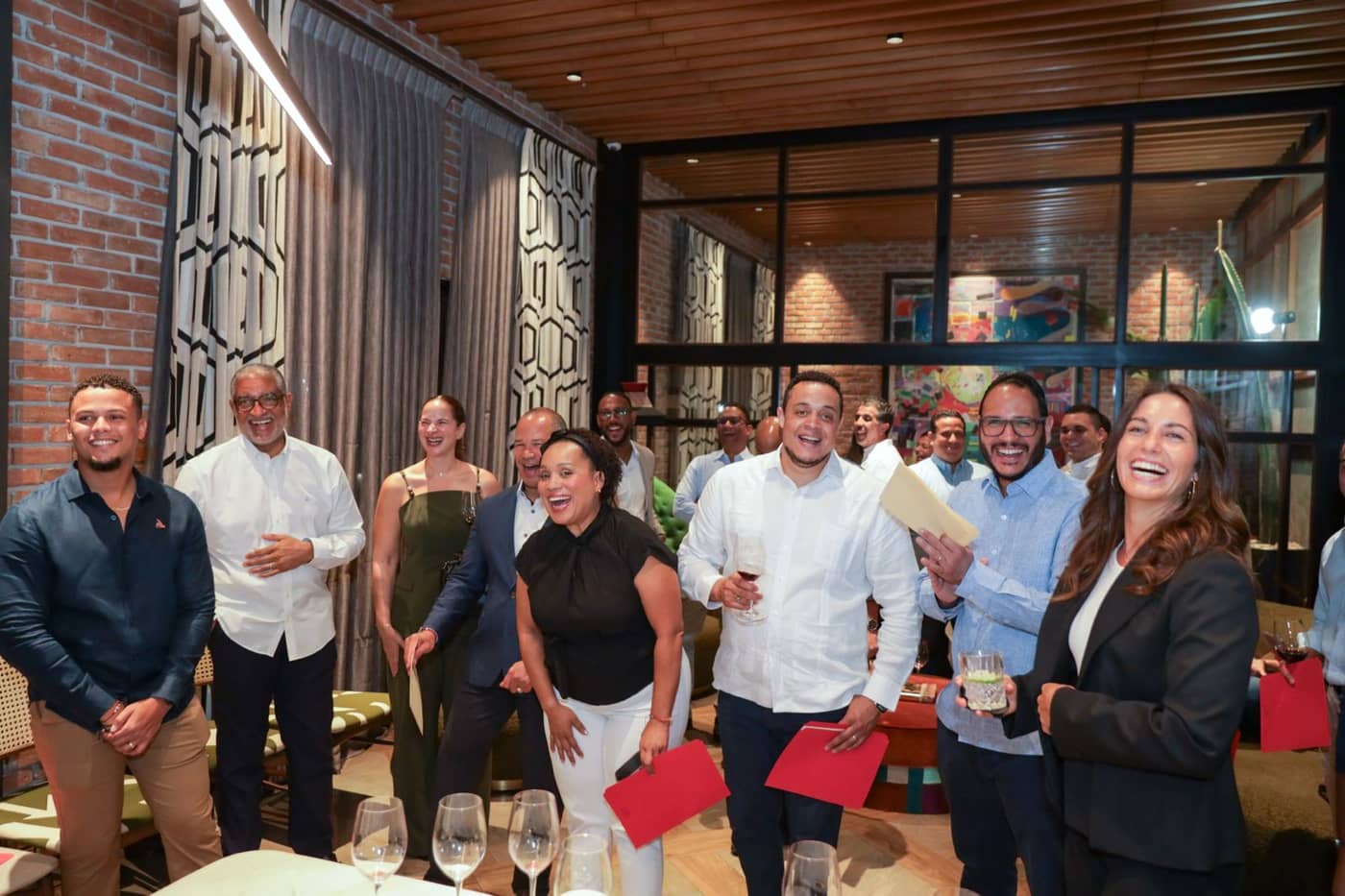 Participantes de la primera cohorte de DLAB celebran con sus carpetas rojas en el evento de cierre